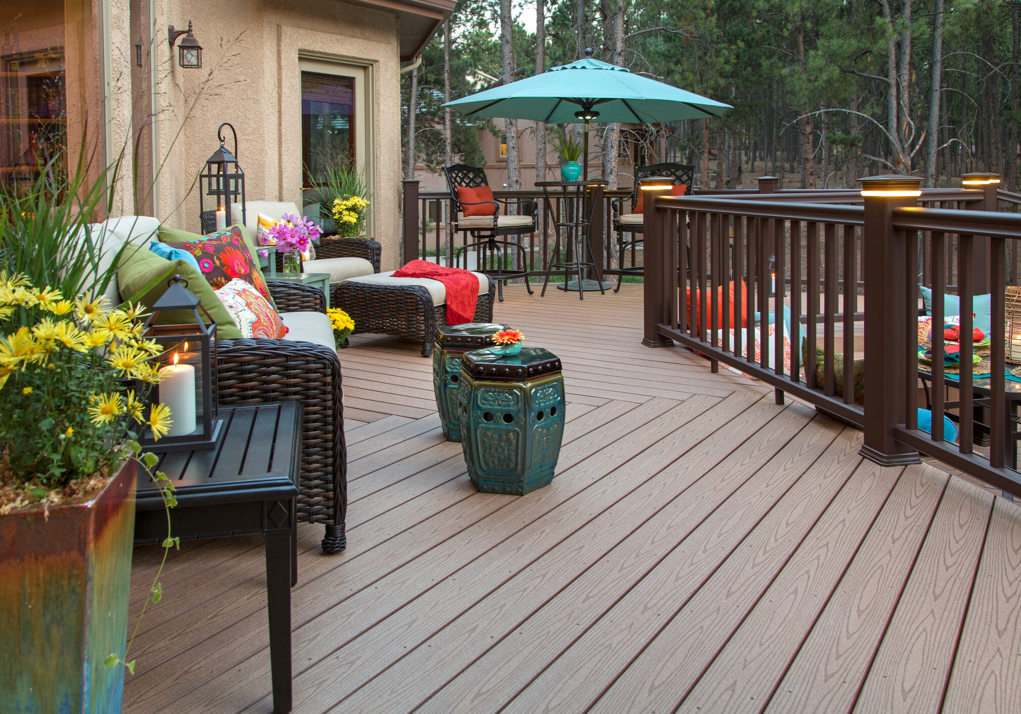 Beautiful backyard deck with built-in lighting and fully decorated with vibrant and colorful furniture and decor
